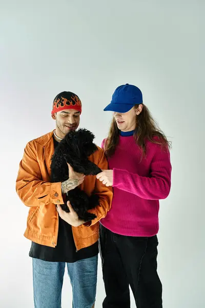 Two men enjoy a serene moment while holding a black dog together. — Stock Photo