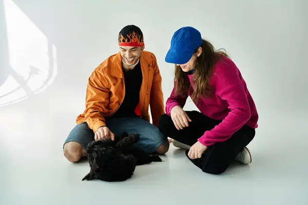 A gay couple and their furry companion sit peacefully on the ground. — стоковое фото