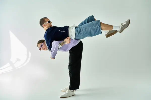 A man confidently handstands on another man, showcasing strength and trust. — Stock Photo