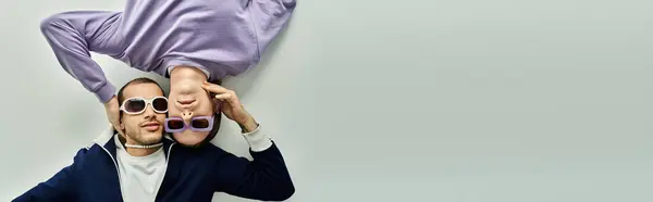 A man in a suit and sunglasses holding up partners head. — Stock Photo