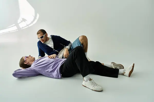 Um atraente casal gay deitado no chão, compartilhando tempo de qualidade juntos. — Fotografia de Stock