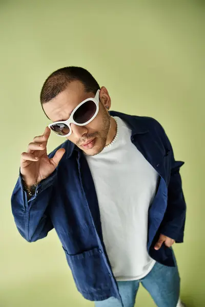 Un uomo in giacca e occhiali da sole in posa con fiducia per una cattura. — Foto stock