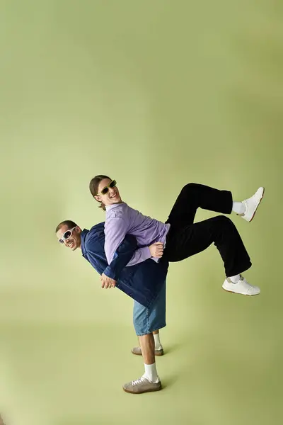 Двоє чоловіків витончено позують перед яскравим зеленим тлом. — стокове фото