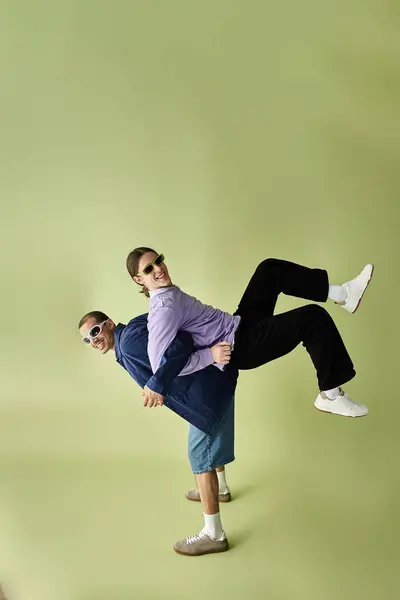 Two men posing gracefully in front of a vibrant green backdrop. — Stock Photo