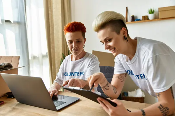 Zwei junge Männer sitzen an einem Tisch, konzentrieren sich auf Aufgaben auf einem Laptop-Bildschirm und arbeiten an einem gemeinsamen Projekt. — Stockfoto