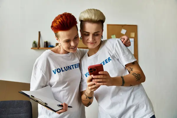 Una coppia lesbica, vestita con magliette volontarie, si è unita in opere di beneficenza. — Foto stock