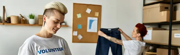 Young lesbian couple in volunteer t-shirts doing charity work together in a room. — Stock Photo