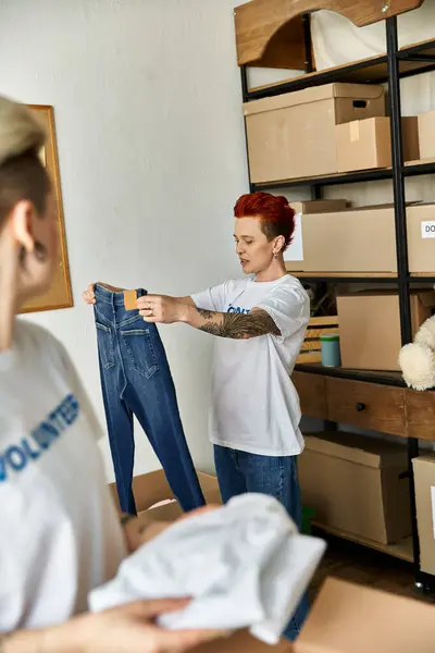 Woman delicately holds a pair of jeans in her hands. — Stock Photo