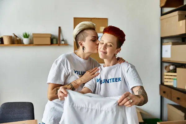Two young women in volunteer t-shirts stand side by side, showcasing unity and commitment to charity work. — Stock Photo