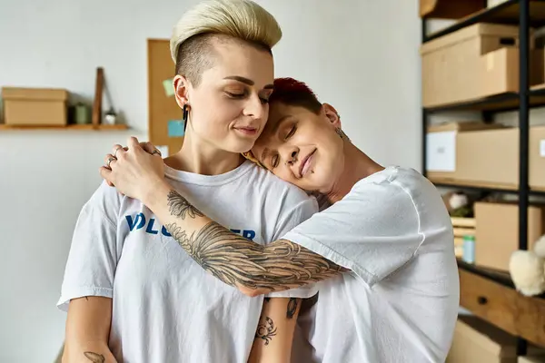 Lesbian couple with tattoos on arms embracing each other warmly. — Stock Photo