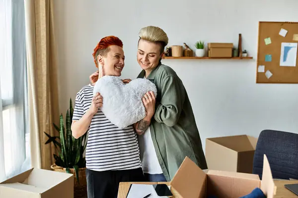 Dos mujeres jóvenes, una pareja de lesbianas, están juntas en una habitación, unidas en su trabajo de caridad. — Stock Photo