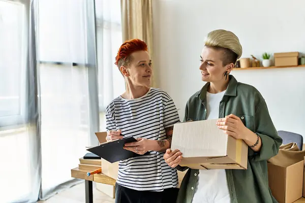 A young lesbian couple, stand together, united in their charity work efforts. — Stock Photo