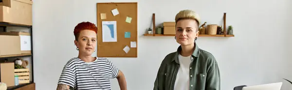 Un jeune couple lesbien, se tient côte à côte, participe activement à un travail de charité. — Photo de stock