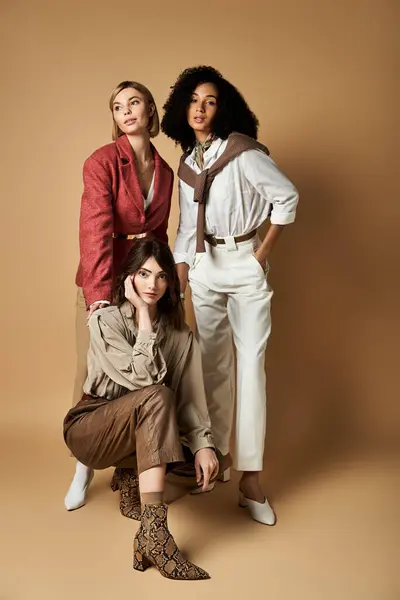 Women of diverse backgrounds and styles strike a pose, embracing friendship and cultural diversity against a beige backdrop. — Stock Photo