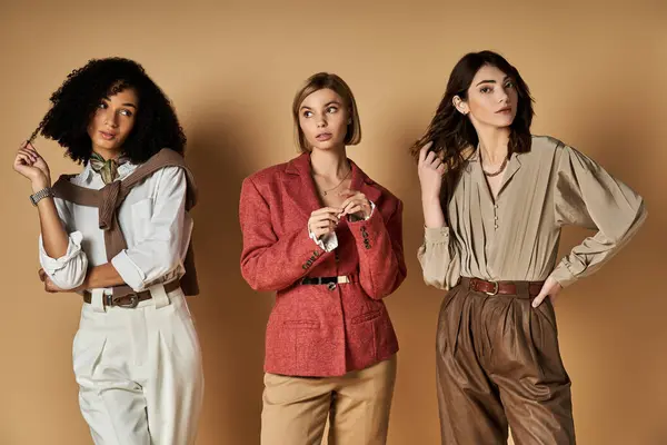 Three young multicultural women in chic outfits stand side by side, showcasing friendship and cultural diversity. — Stock Photo