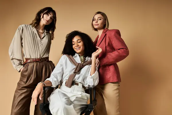 Tre giovani, belle donne multiculturali in elegante abbigliamento posare insieme su uno sfondo beige. — Foto stock