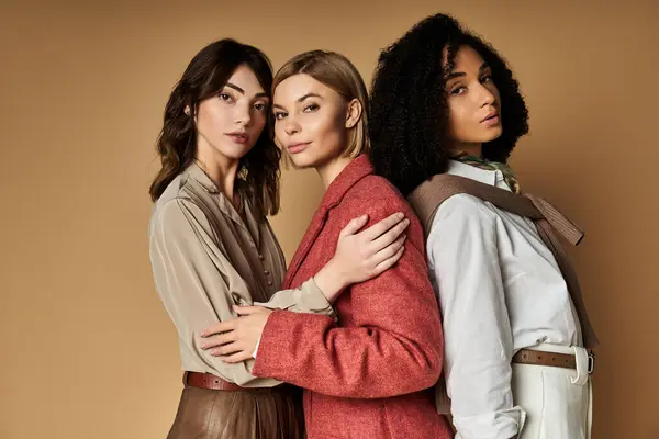 Three young, beautiful women in stylish attire stand together, showcasing diversity in culture and friendship. — Stock Photo
