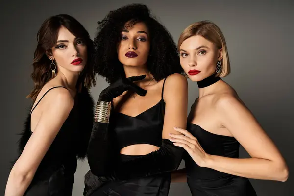 Три молодих красивих жінок різного походження позують разом в елегантних чорних сукнях. — стокове фото