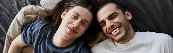 A young gay couple shares a tender moment in their bedroom, their faces illuminated with genuine joy and love. — Stock Photo