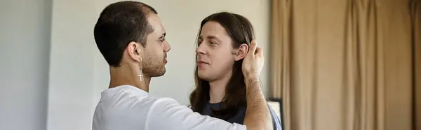 A young gay couple shares a tender moment in their bedroom, showcasing their love and connection. — Stock Photo