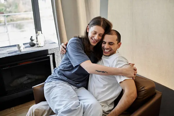 A young gay couple shares a warm and intimate embrace in their modern home, radiating love and happiness. — Stock Photo
