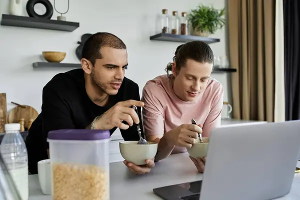 A young gay couple enjoys a casual breakfast together in their modern home. — Stock Photo