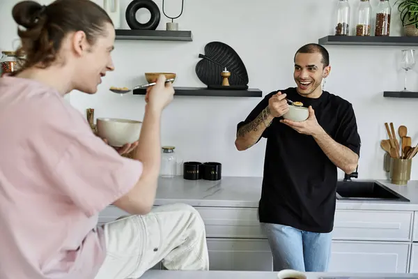 A young gay couple enjoys a casual breakfast together in a stylish modern kitchen. — Stock Photo