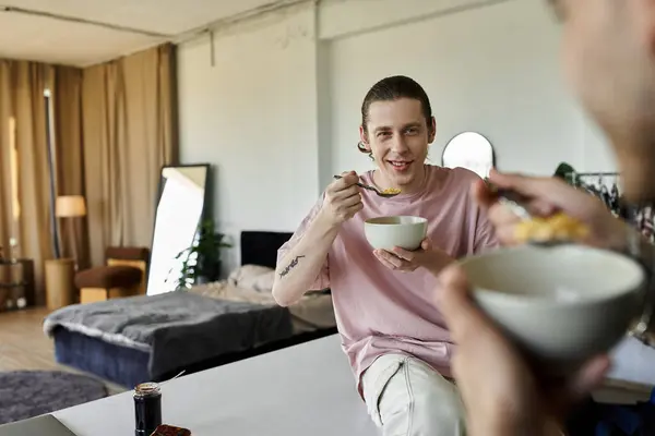 A young gay couple enjoys breakfast together in a modern, well-lit home. — Stock Photo