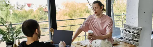 A young gay couple enjoys a coffee break together in a modern home setting. — Stock Photo