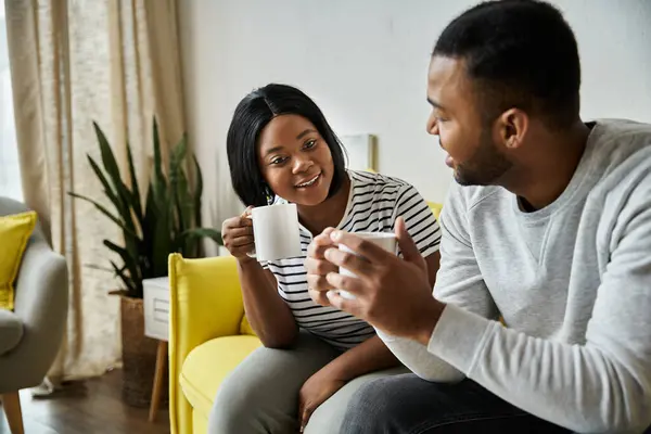 A loving couple shares a warm moment together at home, enjoying a morning beverage and conversation. — Stock Photo