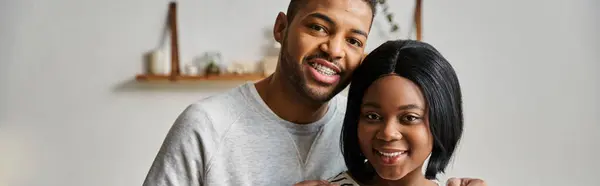 An African American couple smiling and embracing in their home. — Stock Photo
