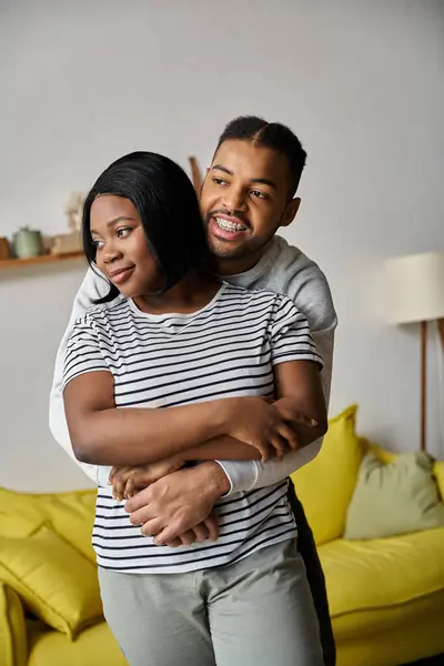 A loving African American couple embraces each other in their home. — Stock Photo