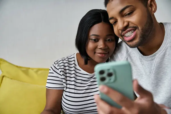 Close-up of African American couple enjoying phone together at home. — Stock Photo