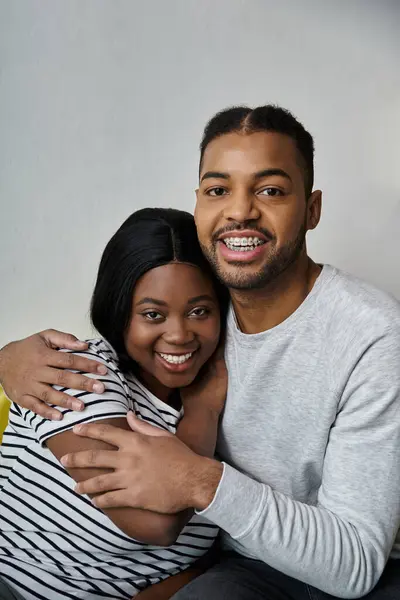 Una coppia afroamericana abbraccia, sorridendo calorosamente alla telecamera. — Foto stock