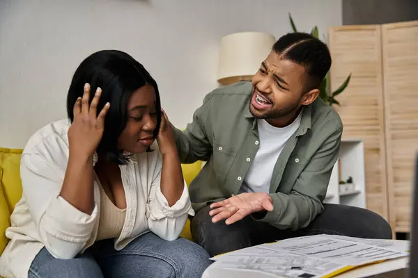 Una coppia afroamericana amorevole si siede su un divano a casa, discutendo di finanze. — Foto stock