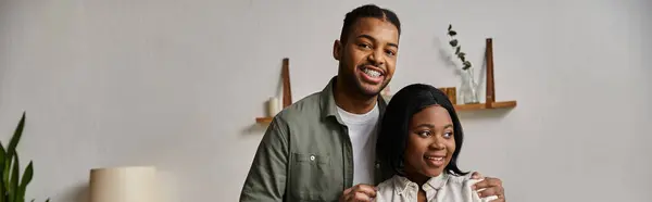 A happy African American couple smiles for the camera in their home. — Stock Photo