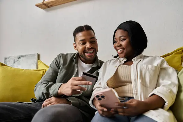 Una coppia afroamericana acquista online con carta di credito e telefono. — Foto stock