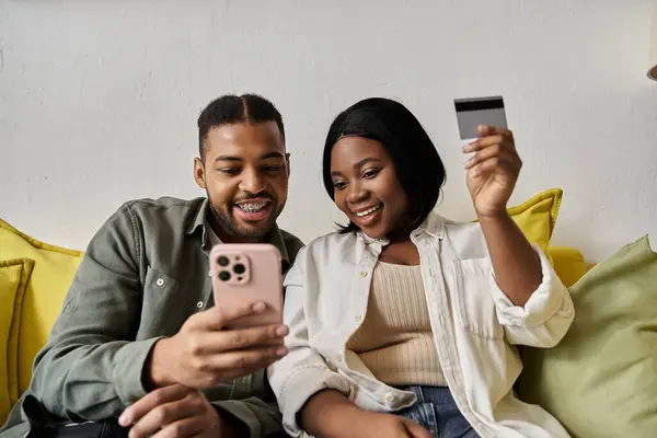 A happy couple makes a purchase together at home. — Stock Photo