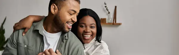 An African American couple embraces warmly in their home, laughing and enjoying each others company. — Stock Photo