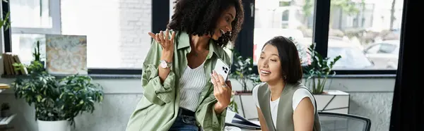 Two women, a lesbian couple, laugh together in their office setting. — Stock Photo
