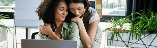 A lesbian couple shares a loving embrace in the office. — Stock Photo