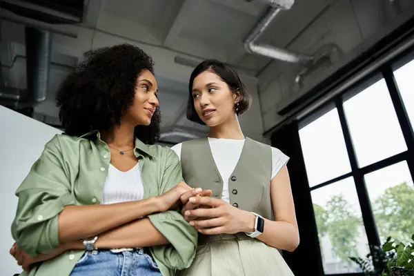 Two women, dressed in office attire, look at each other with affection. — Stock Photo