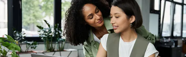 A lesbian couple working together in an office, sharing a loving moment. — Stock Photo