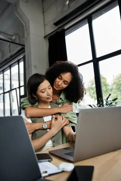 Дві жінки, лесбійська пара, обіймаються в сучасному офісі. — Stock Photo