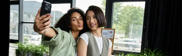 Deux femmes, un couple de lesbiennes, prennent un selfie dans leur bureau. — Photo de stock