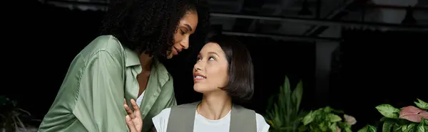 Two women working together in an office, looking at each other with affection. — Stock Photo