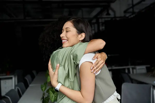Two women in an office setting embrace, showcasing a loving lesbian relationship. — Stock Photo