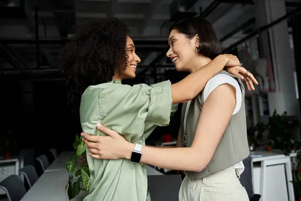 A lesbian couple embraces in an office setting, showcasing their affection and connection. — Stock Photo