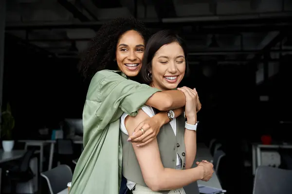 Two women embrace in office, showing love and happiness. — Stock Photo