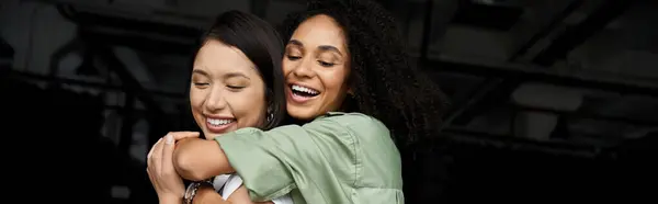 Two women are hugging in an office setting. They appear to be a loving lesbian couple. — Stock Photo